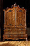 dutch walnut armoire with arched and carved crest above a pair of shaped paneled doors.
