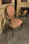 louis xvi gilded open armchair with oval padded back, tapered and fluted legs