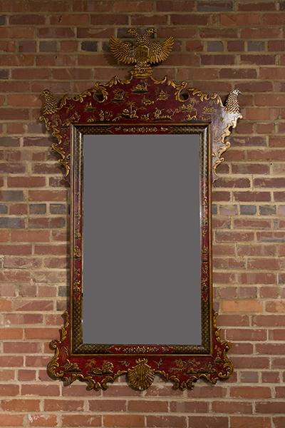 Red laquered mirror with shaped crest terminating in gilt eagles